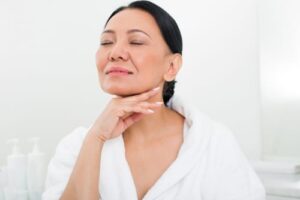 Portrait of calm asian woman rubbing cream with her finger at spa