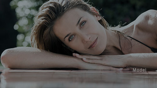 Woman laying her head in her arms while lying on a wooden floor