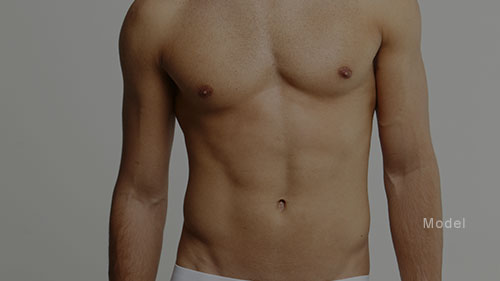 Mid body shot of a man with sculpted abs and chest