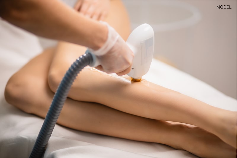 Woman undergoing a laser hair removal treatment on her legs.