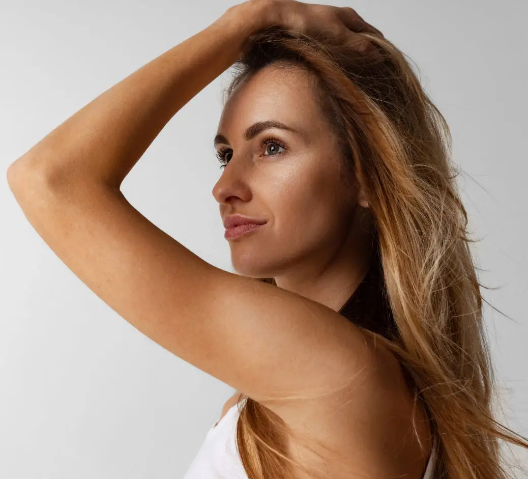 woman in profile with her left hand on top of hair