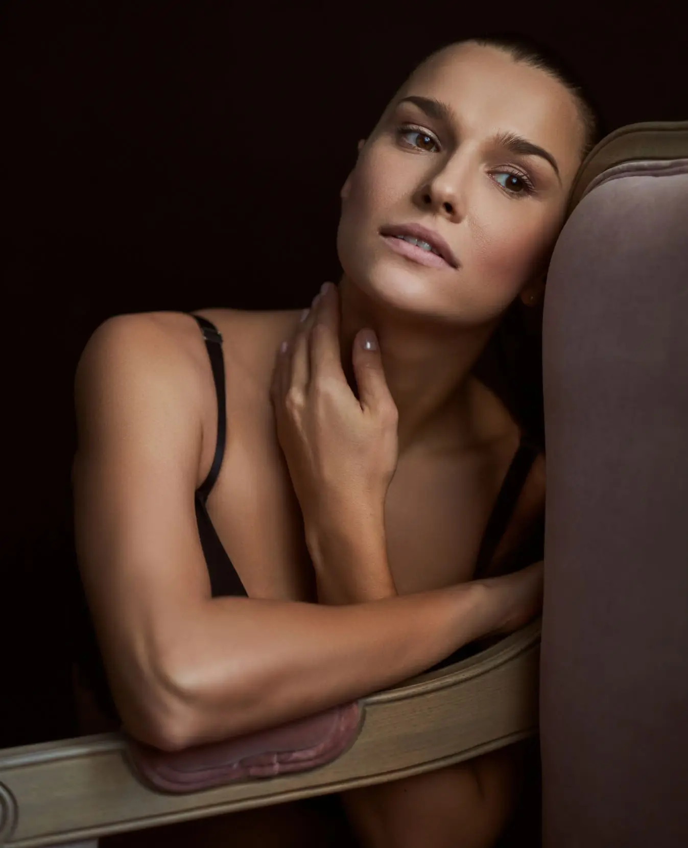 woman sitting on a chair with her arm resting on the arm rest