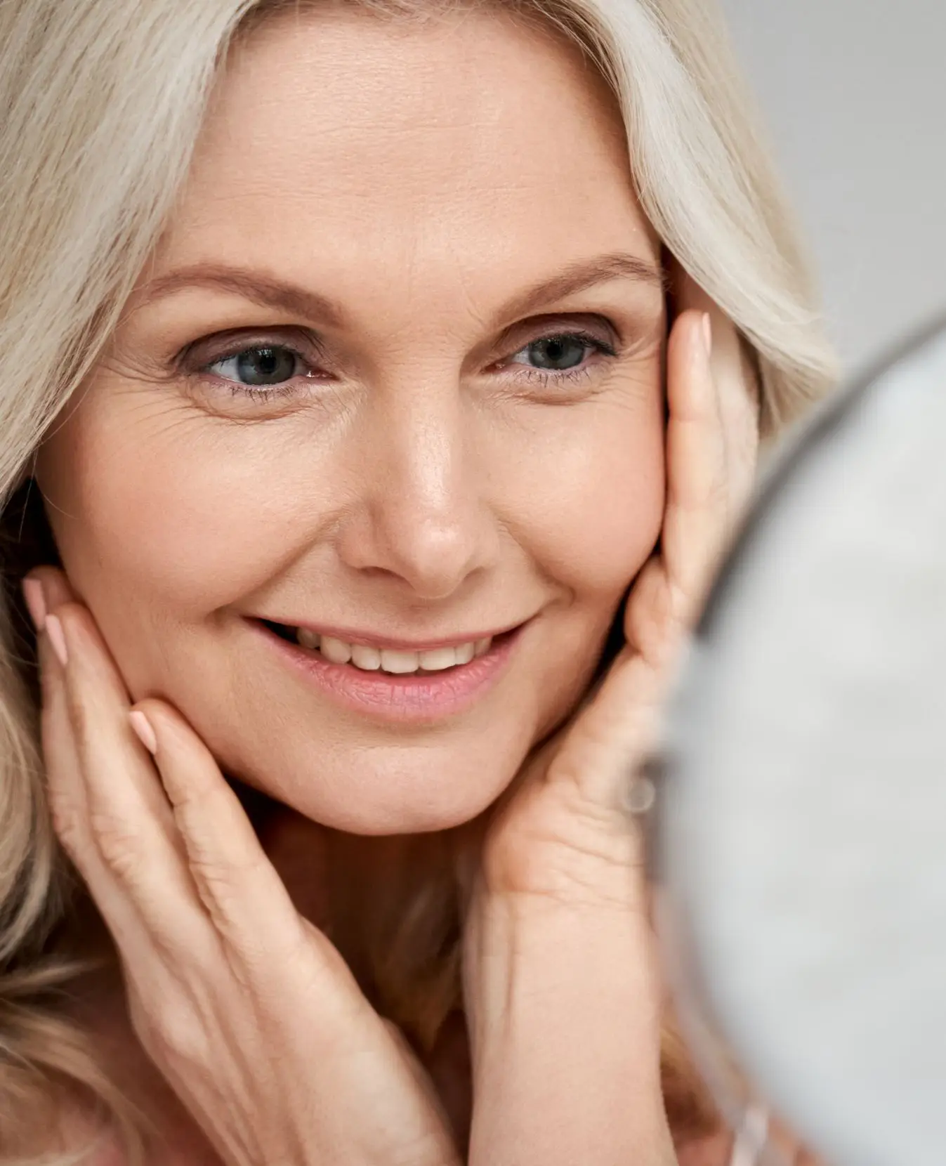 Woman looking in a mirror and touching her face