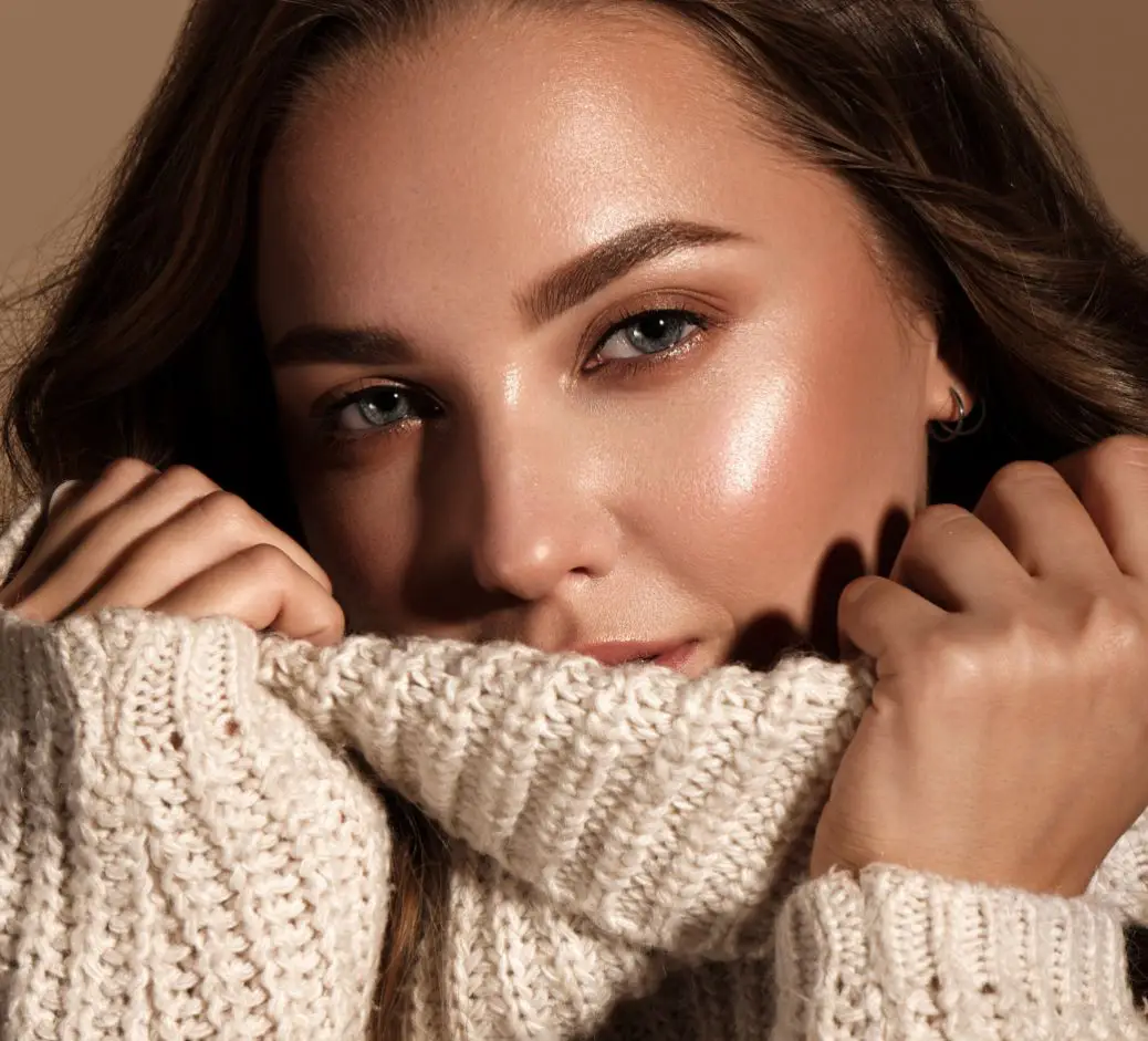 Woman holding her sweater collar over her chin