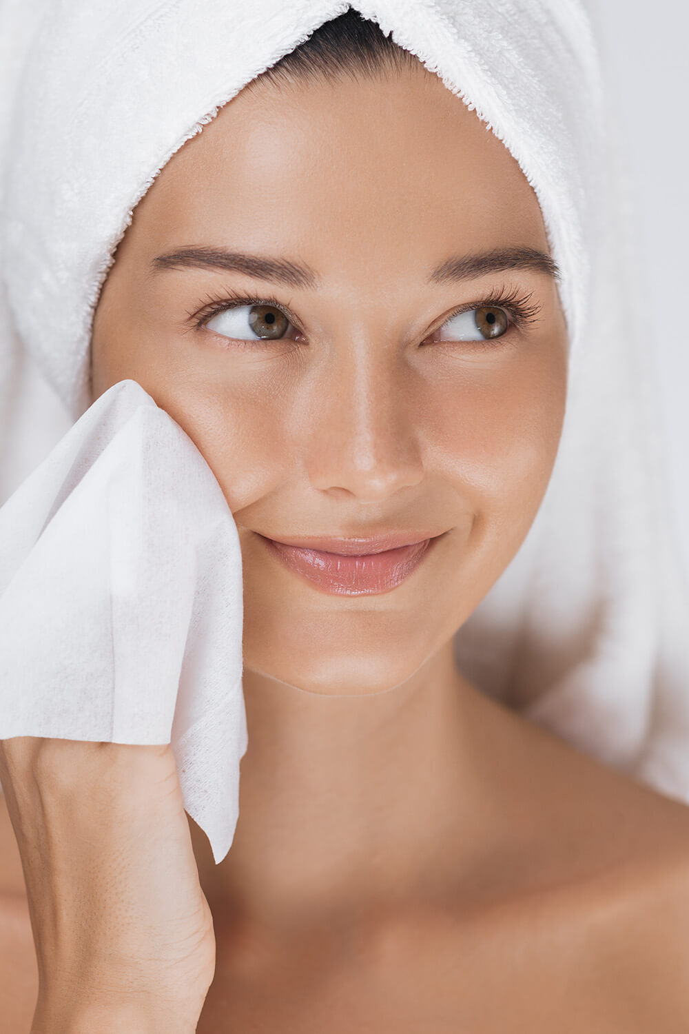 Woman cleaning her face with a towel